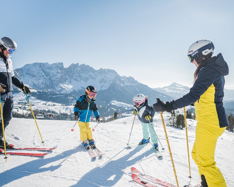Area sciistica familiare Carezza Dolomiti | © Carezza Dolomites/Harald Wisthaler Sciare in famiglia con vista sul Latemar innevato | © Carezza Dolomites/Harald Wisthaler
