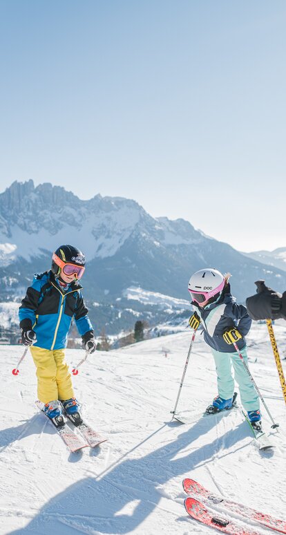 Area sciistica familiare Carezza Dolomiti | © Carezza Dolomites/Harald Wisthaler Sciare in famiglia con vista sul Latemar innevato | © Carezza Dolomites/Harald Wisthaler