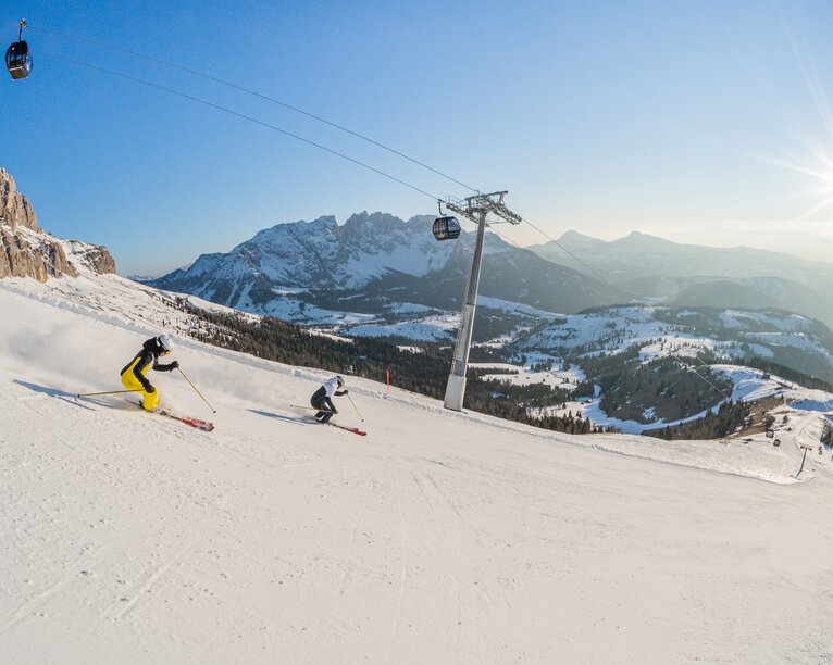 Sciare Carezza Dolomites | © Carezza Dolomites/Harald Wisthaler Sciatore pista Re Laurino Vista sul Latemar | © Carezza Dolomites/Harald Wisthaler