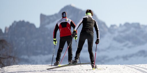Due sciatori di fondo su una pista perfettamente preparata di Nova Ponente con vista sul Catinaccio | © Eggental Tourismus/Günther Pichler