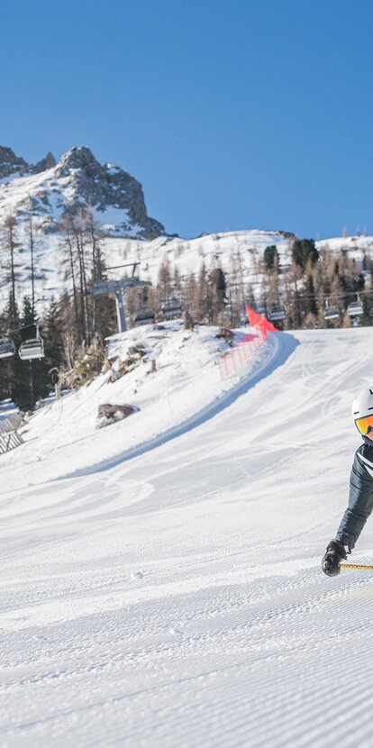 Skifahrerin Carezza Dolomites | © Carezza Dolomites/Harald Wisthaler Skifahrer Abfahrt Pra di Tori Piste im Hintergrund Latemar | © Carezza Dolomites/Harald Wisthaler