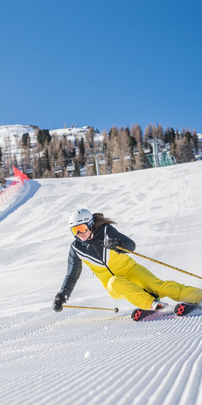 Skifahrerin Carezza Dolomites | © Carezza Dolomites/Harald Wisthaler Skifahrer Abfahrt Pra di Tori Piste im Hintergrund Latemar | © Carezza Dolomites/Harald Wisthaler