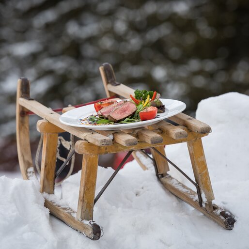 Beef & Snow in the Eggental | © Günther Pichler Plate with beef steak and vegetables on a sledge in the snow | © Günther Pichler