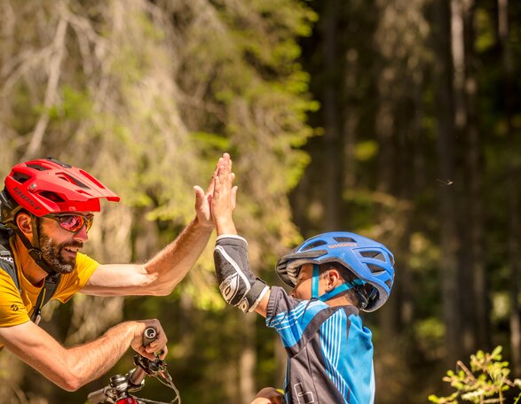 Mountainbiken mit Familie im Eggental | © Eggental Tourismus/Jens Staudt High Five Mountainbiker Sohn und Vater | © Eggental Tourismus/Jens Staudt