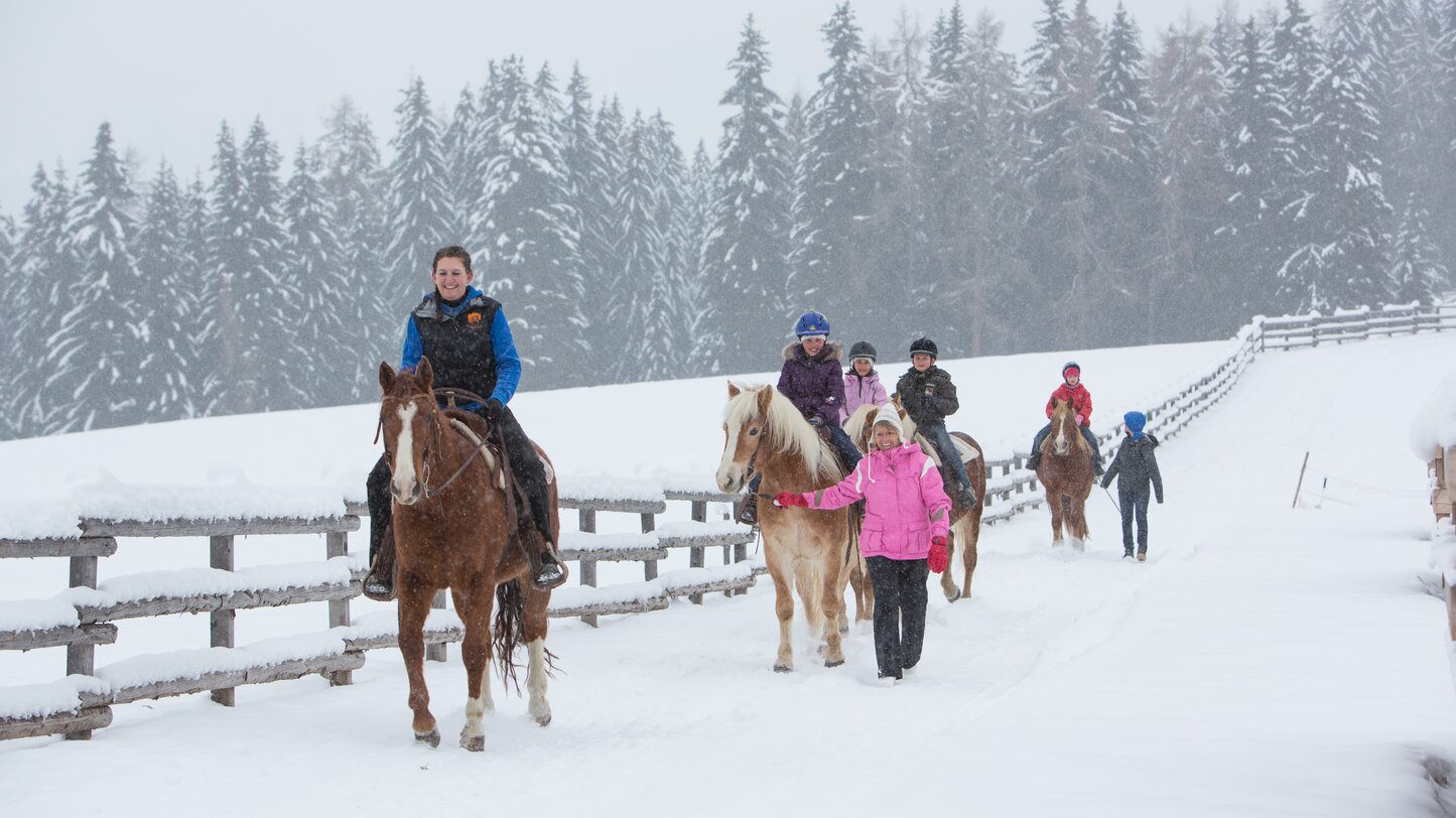 Kinderreiten im Winter Angerle Alm Karersee | © Anerle Alm Gruppe von Kindern reitet durch frischen Schnee | © Anerle Alm